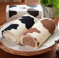 two towels on a plate with a cow figurine next to it