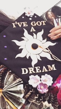 a graduation cap with the words i've got a dream on it and flowers