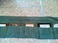 three framed pictures are in the pocket of a green towel that has been folded over