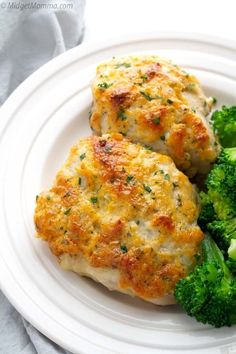 two chicken patties with broccoli on a white plate