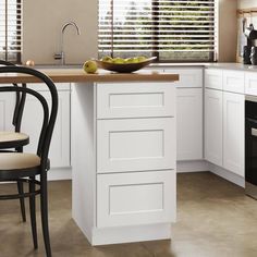 a kitchen with white cabinets and black chairs