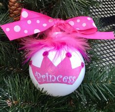 a princess ornament hanging on a christmas tree with pink and white polka dots