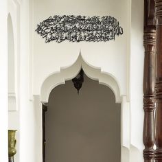 the entrance to a white building with arabic writing on it's walls and an arched doorway