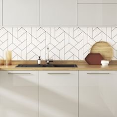 a kitchen with white cabinets and wooden counter tops, along with a wood cutting board