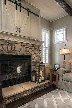 a living room filled with furniture and a fire place in front of a stone fireplace