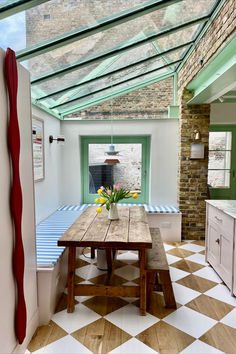 a wooden table sitting in the middle of a kitchen next to a white and brown checkered floor