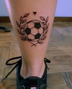 a person with a tattoo on their leg that has a soccer ball in the center