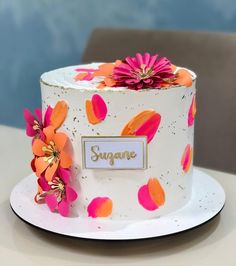 a white cake with pink and orange flowers on it