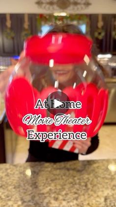 a person holding up a red object with the words at home music theater experience on it