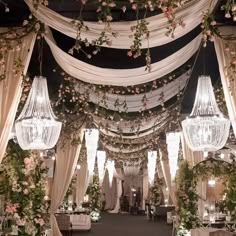 an outdoor wedding venue with chandeliers and flowers