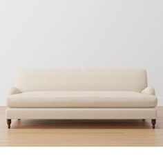 a white couch sitting on top of a hard wood floor