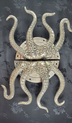 two metal octopus sculptures sitting on top of a wall