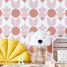 a teddy bear sitting on top of a wooden chair next to a wall with circles