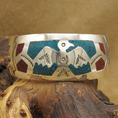 "Sterling silver thunder bird cuff bracelet. There is turquoise color chip inlay around the thunder bird. The two ends have red inlay. The inside measures 6 1/2\" including the 7/8\" opening. The inside is stamped 925 Sterling. The bracelet can't be bent to size because of the inlay. It is in good condition. Thank you for looking. Please let us know if you have questions.\\ BT-1 k *The color on your screen may not reflect actual stone color due to variations in monitors*" Thunder Bird, Color Chip, Turquoise Color, Tucson, Cuff Bracelet, Stone Color, Cuff Bracelets, Jewelry Bracelets, Two By Two