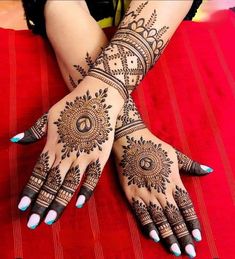 a woman's hands with henna tattoos on them