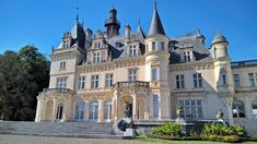 a large castle like building with many windows and stairs leading up to the front door