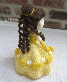 a crocheted doll wearing a yellow dress