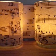 three lit candles with sheet music on them