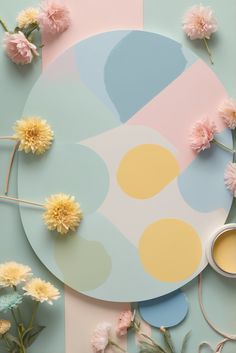 some flowers and scissors on a table with pastel blue, pink, yellow and white designs