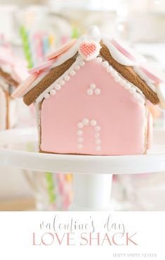 a pink house shaped cookie on a white plate