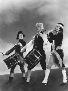 three women dressed in costumes holding drums