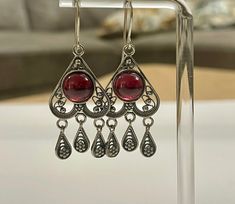 Treat yourself or your loved ones to a touch of luxury with these stunning Sterling Silver 925 earrings. These drop earrings are adorned with brilliant red garnet stones, perfectly integrated into the intricate and elegant filigree work. The delicate filigree craftsmanship highlights the natural beauty of the garnet stones, adding a sense of magic and romance to the earrings. These sterling silver earrings with garnet stones in a filigree design are the perfect choice for any woman looking to ad Red Garnet Earrings, 925 Earrings, Sterling Silver Drop Earrings, Garnet Earrings, Garnet Stone, Filigree Design, Fancy Jewelry, Silver Drop Earrings, Red Garnet