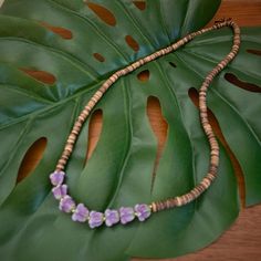 Crown Flower Collection - 30" Crown Flower Lei Beaded Necklace #7 made with LOVE and ALOHA created with handcrafted purple clay crown flower beads, coconut shell beads, small gold plated spacer beads on 100% black silk cord. This item includes eight large purple crown flower beads and pairs beautifully with matching Crown Flower Collection Bracelet #5. This everlasting lei is stunning and includes a feel good donation of 10% of proceeds donated to the Waipa Foundation on the Garden Island of Kauaʻi. Crown Flower Lei, Clay Crown, Yellow Flower-shaped Beaded Necklaces With Colorful Beads, Unique Adjustable Flower-shaped Beaded Necklaces, Yellow Flower-shaped Beaded Necklace, Multicolor Flower-shaped Beaded Necklaces, Artisan Flower-shaped Colorful Beaded Necklace, Garden Island, Purple Crown