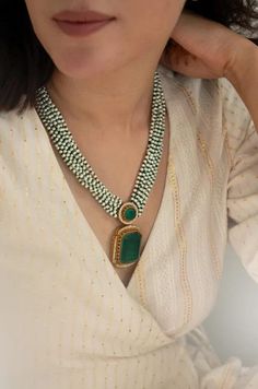 Pearls have been regarded for centuries due to their classic, yet exquisite allure, and the Sahin Necklace is a remarkable homage to the elegance of these luxuries. Crafted with trinkets of green onyx and pearls, this precious keepsake is complete with an emerald-crystal centerpiece, sure to remain an heirloom for years to come. Closure - Adjustable Dori Weight - 66.35gm Crystal Centerpieces, Kundan Necklace Set, Emerald Crystal, Kundan Necklace, Bollywood Jewelry, Emerald Pendant, Kundan Necklaces, Jewelry Statement, Inspired Jewelry