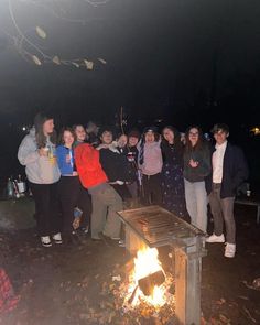 a group of people standing around a fire pit