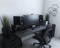 a desk with a computer and speakers on it