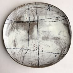 a white plate with black and blue designs on the rim is sitting on a table