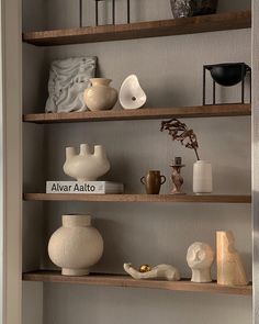 shelves with vases and other decorative items on them in a living room or dining room