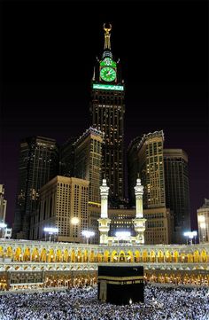 a large group of people standing in front of a building with a clock on it