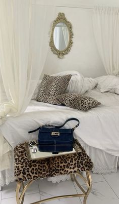 a leopard print foot stool in front of a white bed