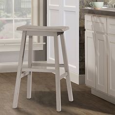 a white stool sitting in front of a window