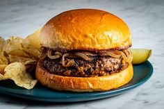 a hamburger and chips on a blue plate