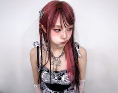 a woman with long red hair and piercings on her head is posing for the camera