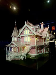 a large pink house on display in the dark