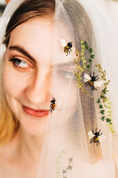 a woman wearing a veil with bees on it