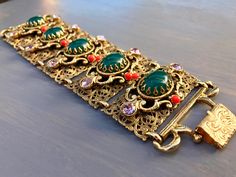 "Details: A phenomenal and super rare unsigned Selro bracelet Wide gold tone filigree panels Large green glass cabochons Lavender rhinestones and coral balls Confirmed Selro Secures with a gold over clasp Feel like a Mughal princess in this piece! Measurements: Approx 7 1/2\" long and 2 1/4\" wide! Condition: Excellent vintage condition with lightest signs of age-appropriate use and wear. No damage or flaws noted Have a question? Please send me a message! my shop: www.etsy.com/shop/mygildedmagpi Mughal Princess, Slide Jewelry, Rare Jewelry, Jewish Women, Chandler Az, Semi Precious Gems, Mom Jewelry, Jewelry Statement, Pink Jewelry