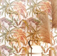 a wallpaper with giraffes and palm leaves on it, next to a lamp