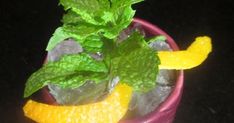 a cup filled with ice, lemon and mint