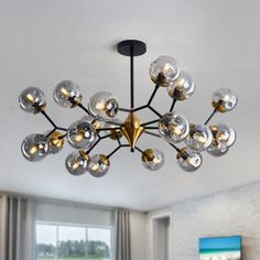 a modern chandelier hanging from the ceiling in a living room