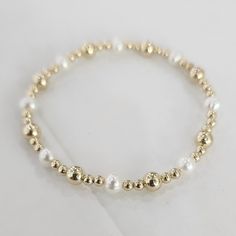 "* 3 mm (Round) and 5 mm (Round) Gold Filled (14/20) Beads * Fresh Water Pearls * Also available in sterling silver * Available in Various Sizes. Please choose from drop down list. I make 6.5\" for most wrist size and 5.5\" for kid's size. To determine your bracelet size: Measure with a tape around your wrist (where you would like the bracelet to sit). If you don't have access to a measuring tape, wrap a string around your wrist and measure the length with a ruler. This is your wrist size. To de Dainty 14k Gold-filled Stretch Bracelet With Gold Beads, Gold 14k Gold-filled Tiny Beaded Bracelets, Gold Beaded 14k Gold-filled Pearl Bracelet, 14k Gold-filled Pearl Bracelet With Round Beads, Gold Stretch Bracelet With 14k Gold-filled Beads, Jewelry Stacking, Fresh Water Pearls, Bracelet Boho, Stacked Jewelry