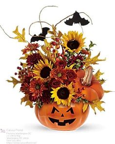 a pumpkin arrangement with sunflowers and other flowers