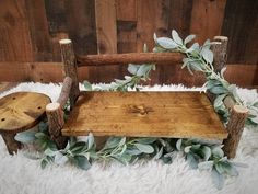 a wooden bench made out of logs and branches with greenery on the backrest