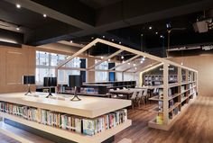 a library with bookshelves, tables and lamps