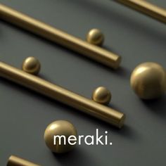 several brass colored handles and knobs on a black surface with the word merak written below them