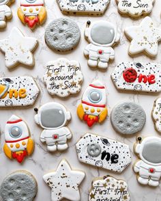 decorated cookies with the words first trip around the sun and astronaut on them are displayed