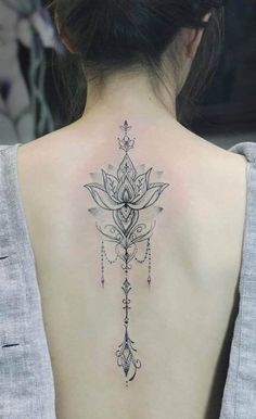 the back of a woman's neck with a lotus tattoo on it